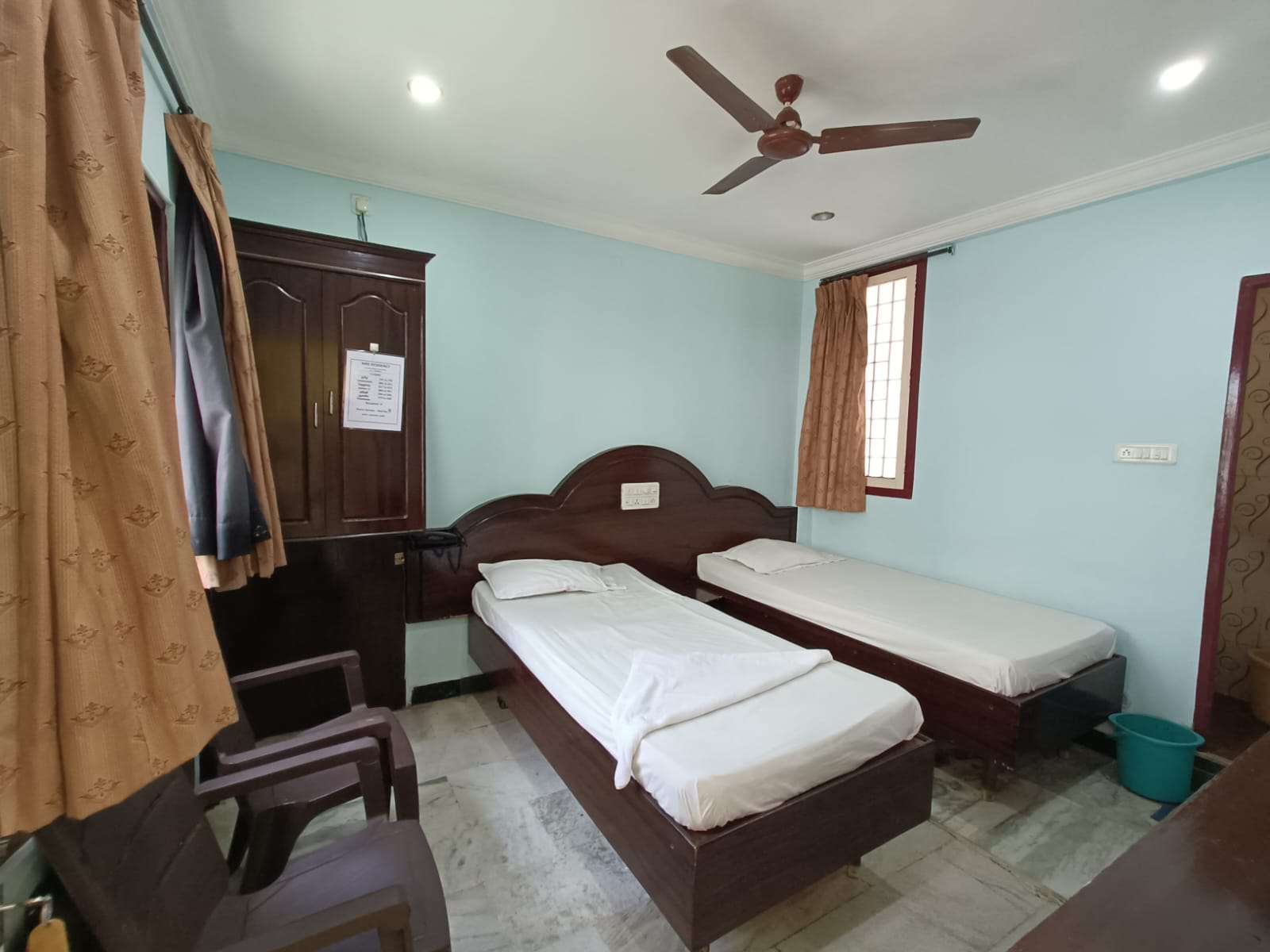 Twin guest room with two beds and a ceiling fan
